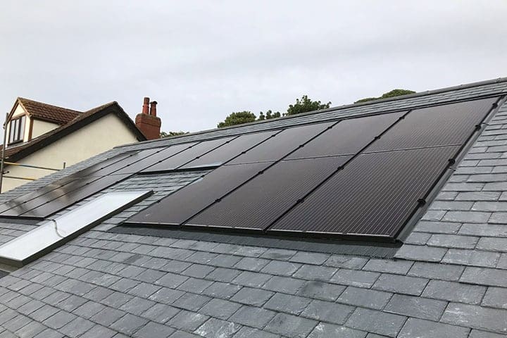 Black solar panels built into a grey roof 