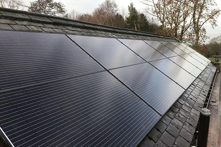 Black solar panels on a roof with grey slate tiles