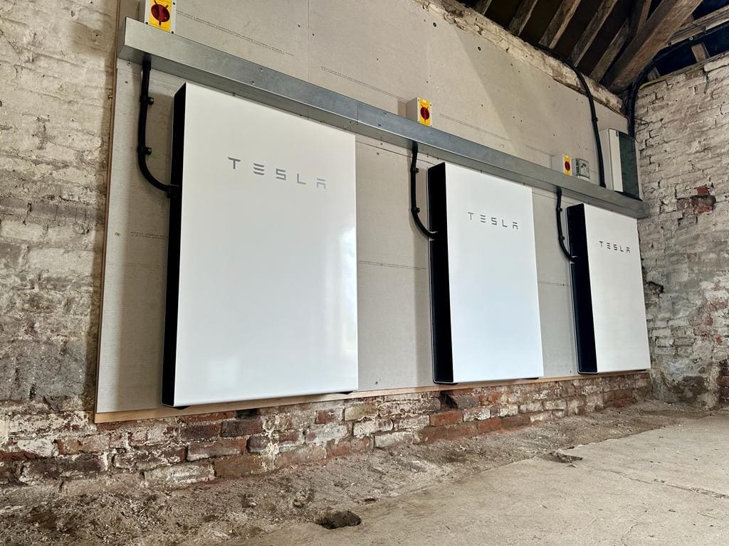 Three Tesla Powerwall batteries on a wall
